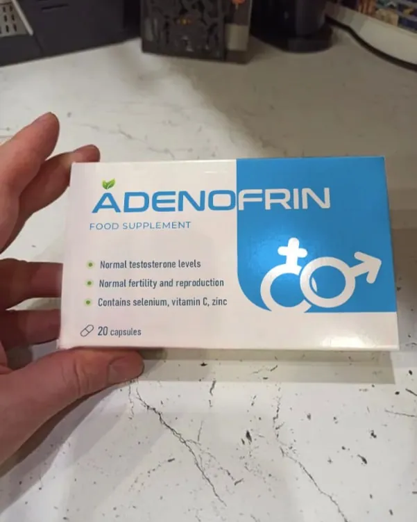 Mano che tiene una confezione di Adenofrin su un tavolo di marmo